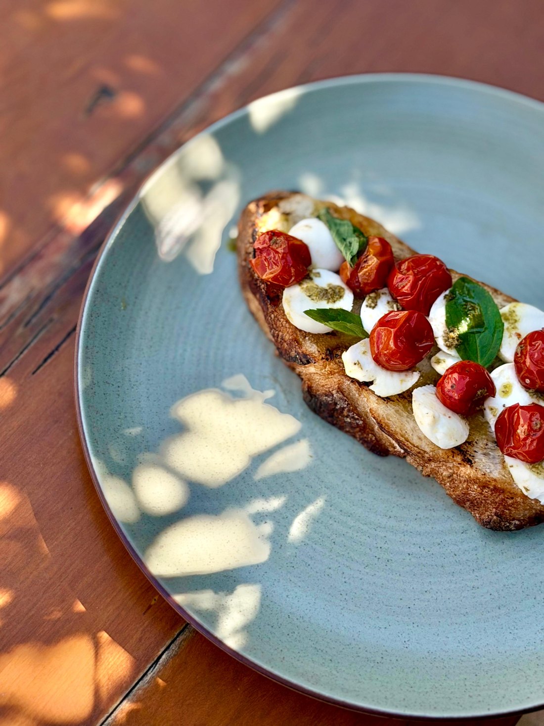 Toast caprese com tomates assados, muçarela de búfala e manjericão